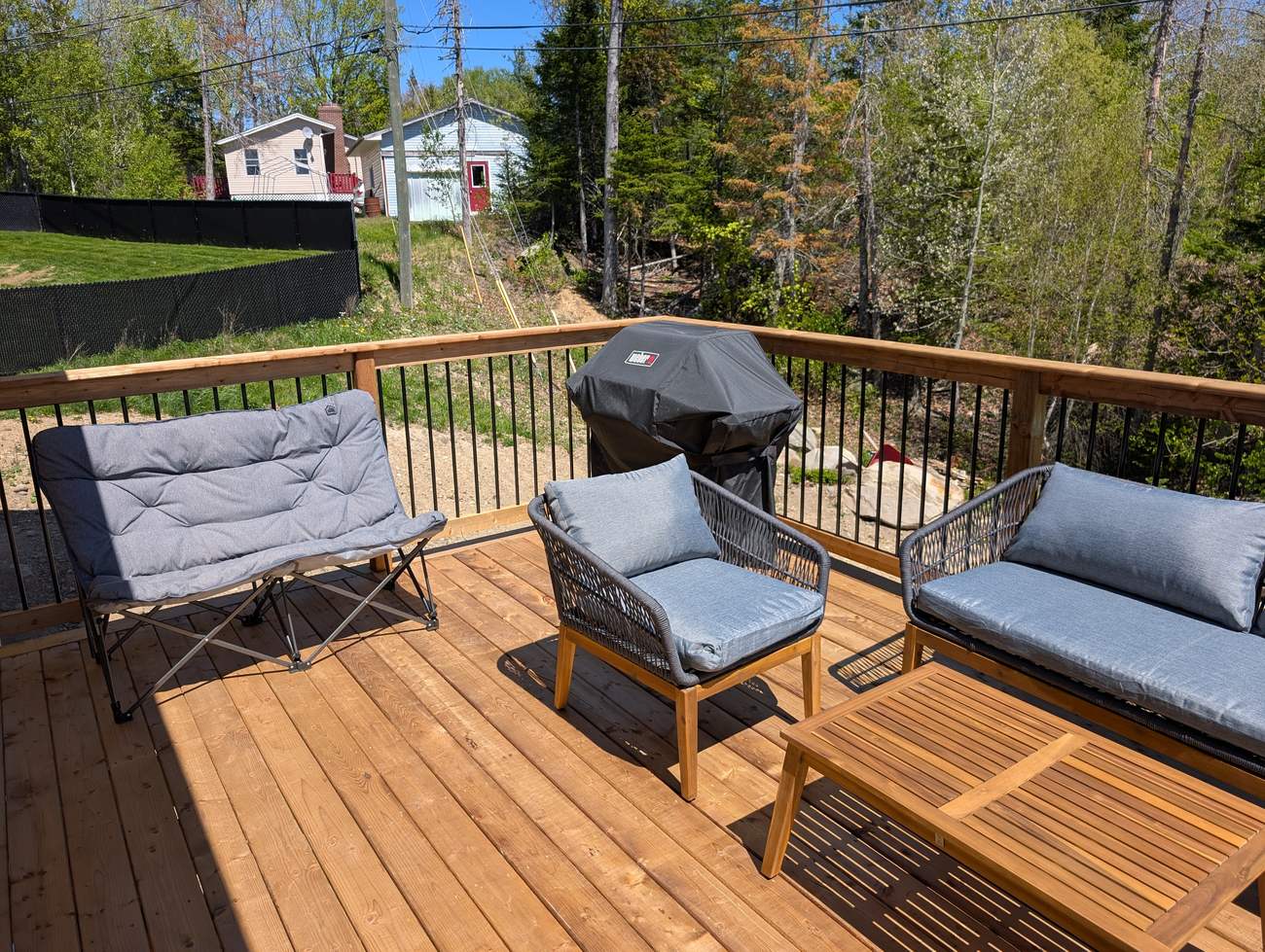 Rear deck with seating, looking out over the back yard and trees