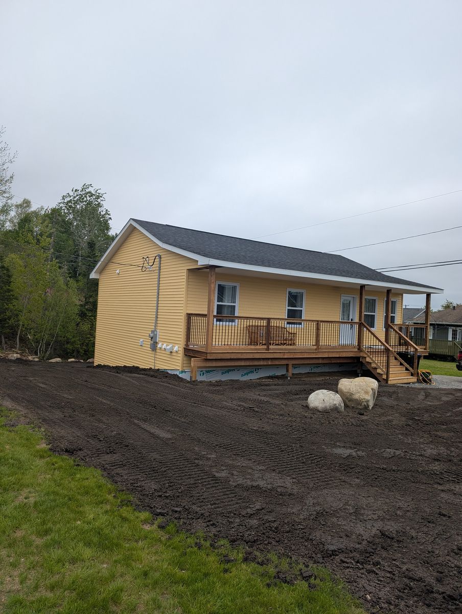 Side view of the finished home showing the covered porch and yard